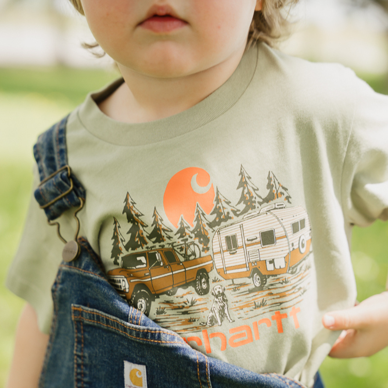 Child wearing a t-shirt with a camping design and Carhartt logo.