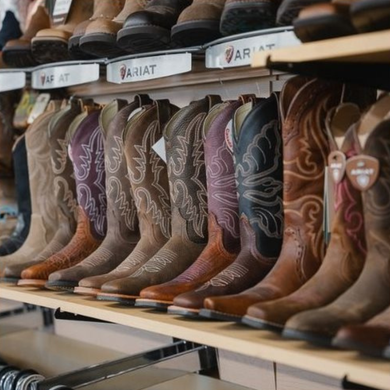 Row of Ariat cowboy boots on display in a store.